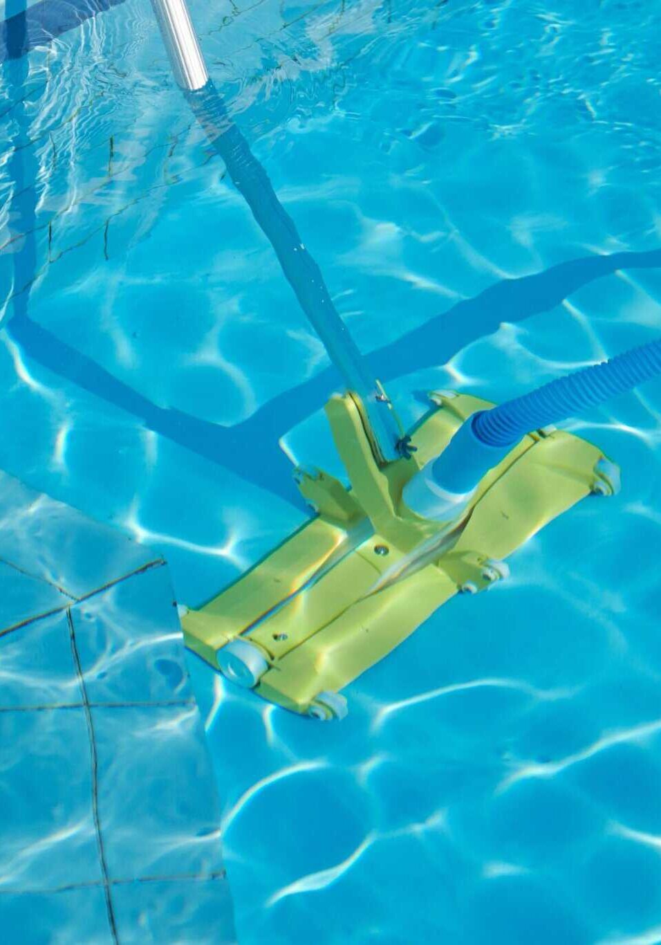 close up of outdoor swimming pool underwater, cleaning vacuum tube
