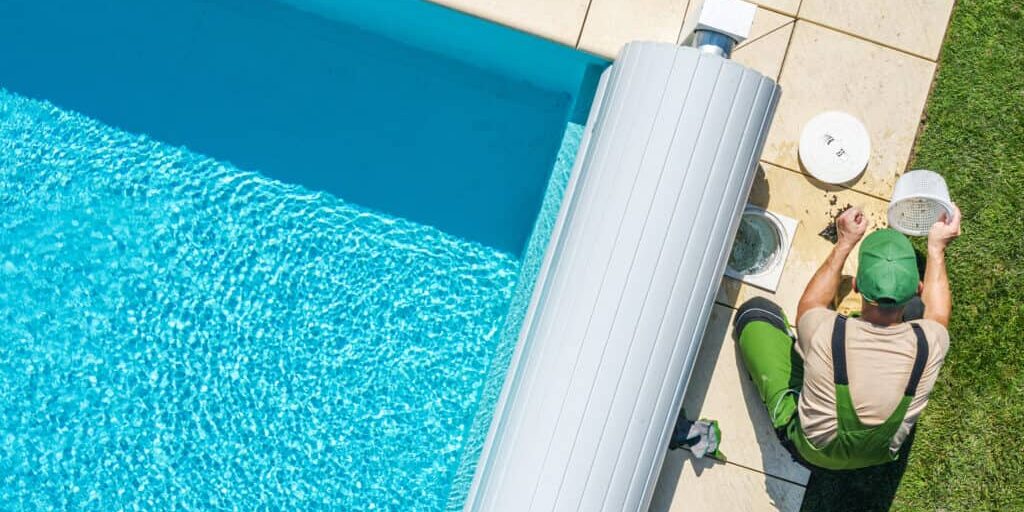 Outdoor Backyard Garden Swimming Pool Maintenance. Caucasian Professional Garden SPA Technician Cleaning Skimmer Filter From Dirt. Outdoor Backyard Garden Swimming Pool Maintenance.