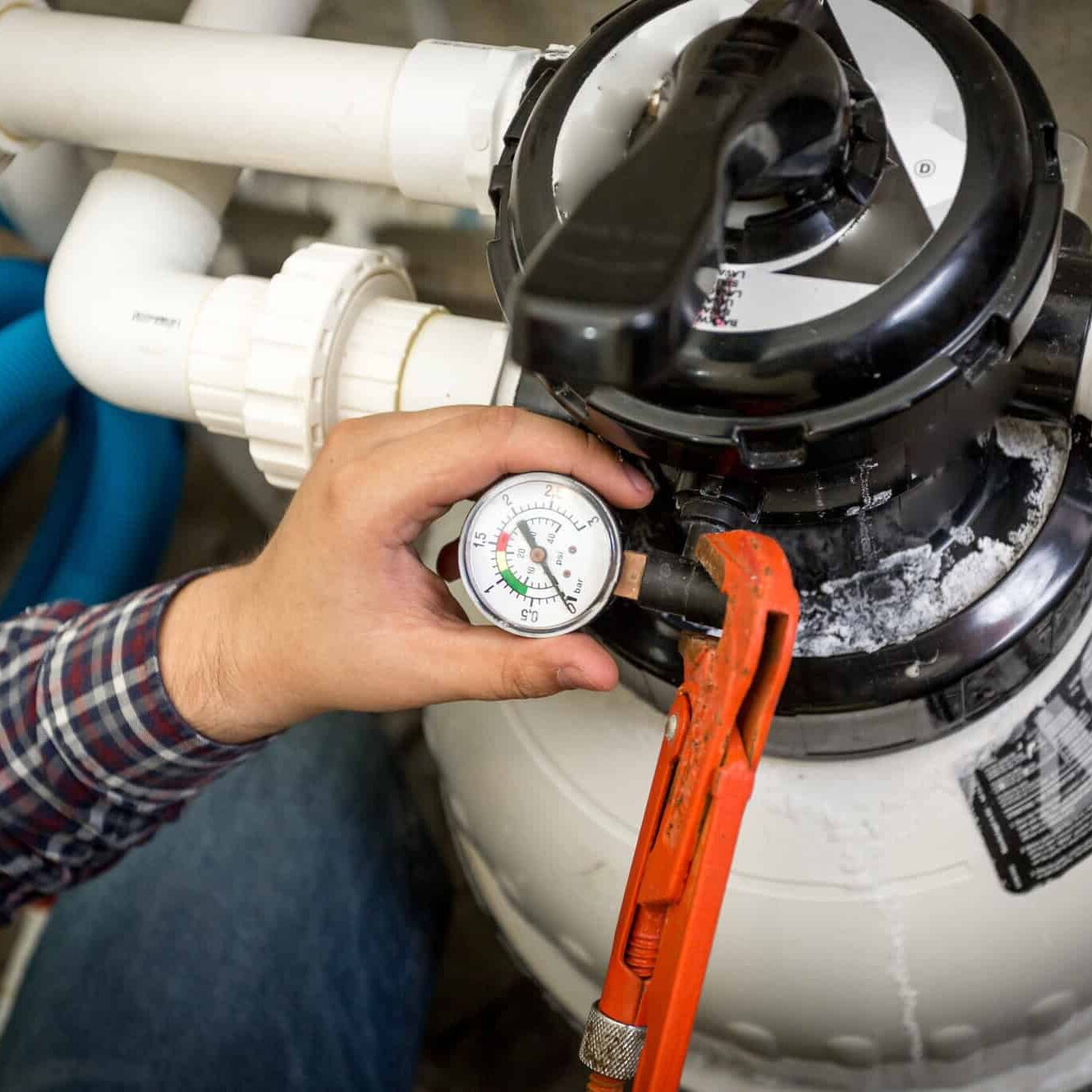 plumber checking manometer on big hydraulic pump Closeup shot of plumber checking manometer on big hydraulic pump