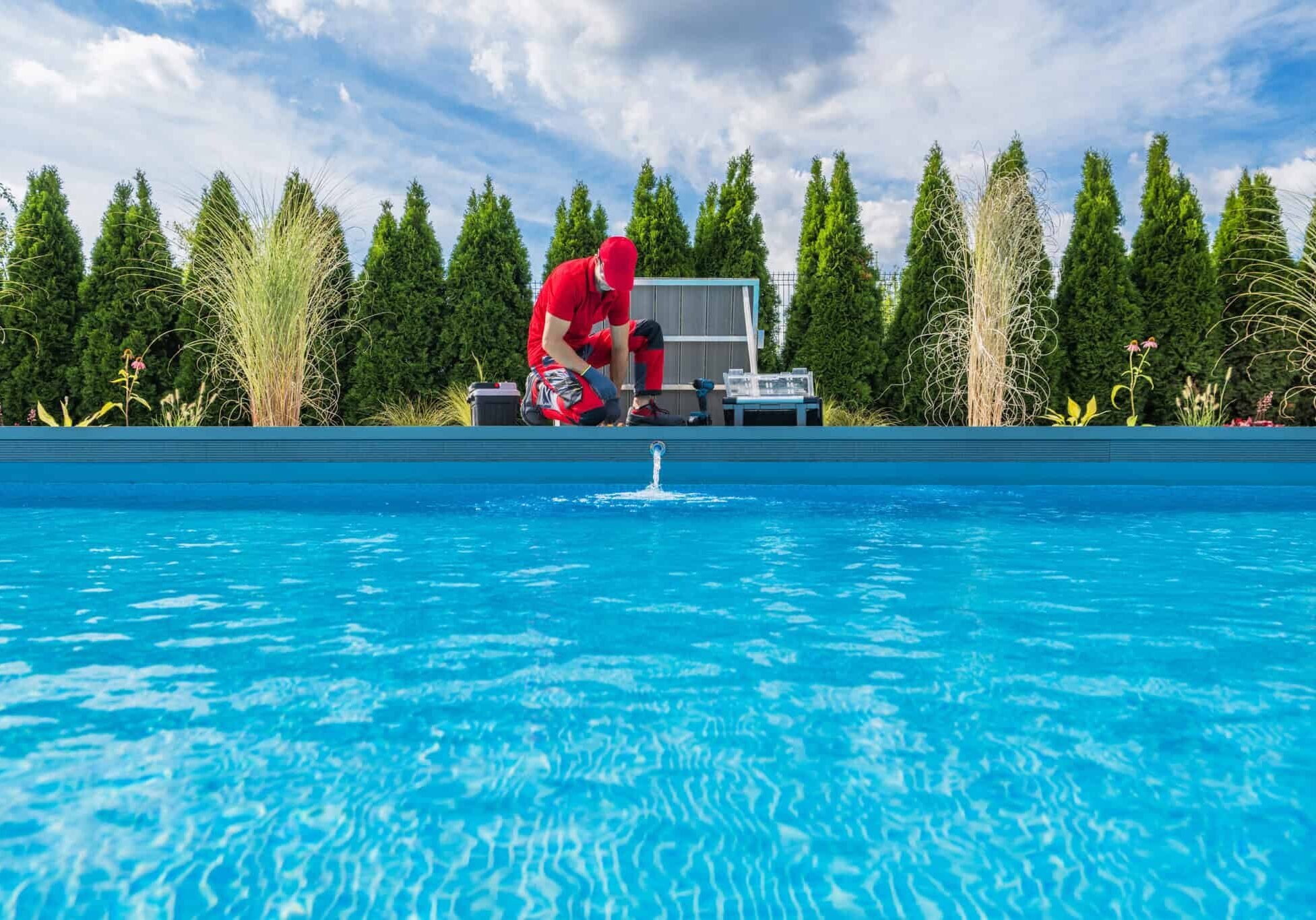 Professional Swimming Pools Technician Performing Seasonal Maint Professional Caucasian Swimming Pools Technician in His 40s Performing Seasonal Maintenance. Outdoor Residential Backyard Pool.